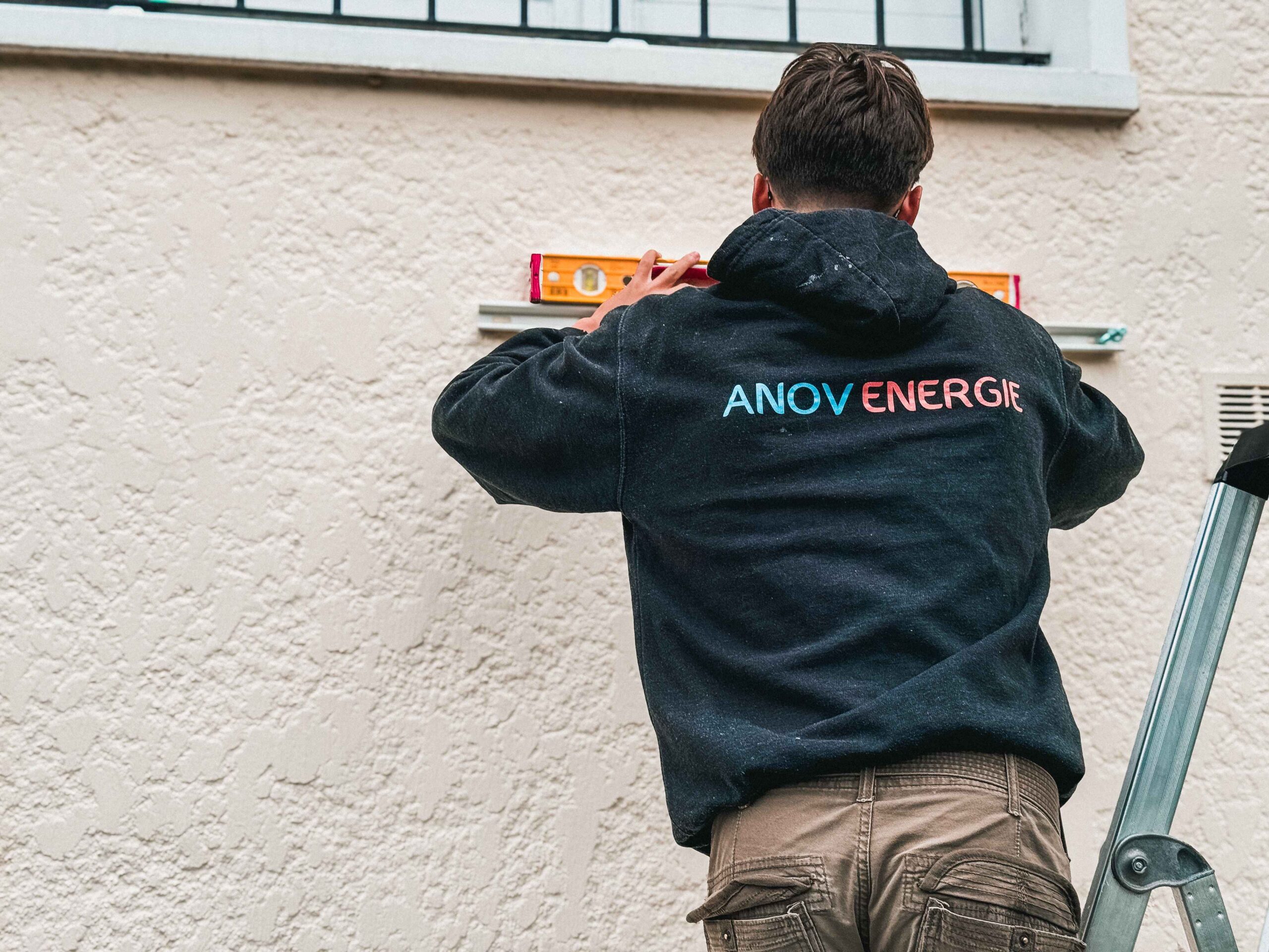 Artisan Anov Energie préparant l'installation d'une climatisation extérieure sur un mur à Noisy-le-Grand (93).