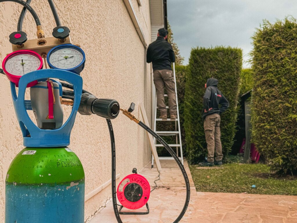 Artisans de Anov Energie préparant l’installation de climatisation avec bouteille de gaz.