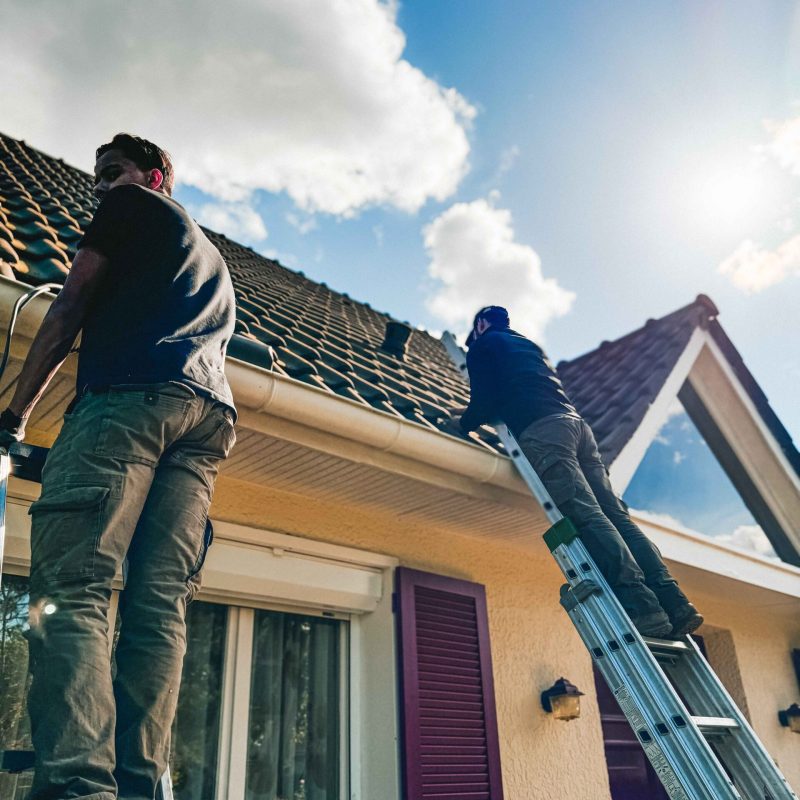 Artisans Anov Energie en train de faire l'installation de climatisation et le passage de câble électrique sur une maison.